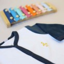 Embroidered musical note on newborn sleepsuit Embroidered musical note on newborn sleepsuit