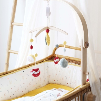 musical mobile with fox hanging above baby's wicker crib