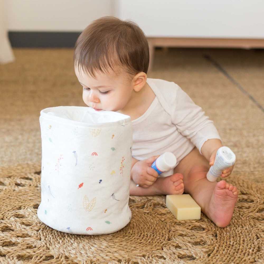 Bebé a olhar para dentro do saco de arrumação para tirar os produtos