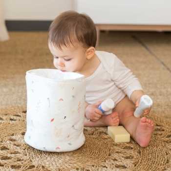 Bebé a olhar para dentro do saco de arrumação para tirar os produtos