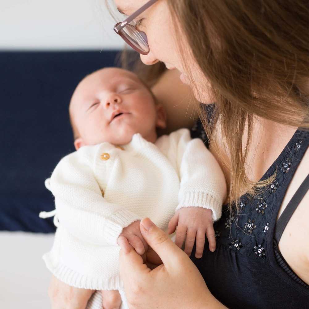 bébé en brassière blanche en point mousse avec sa maman