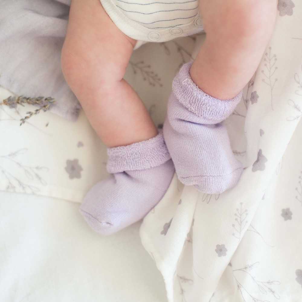 bebé com meias lilases