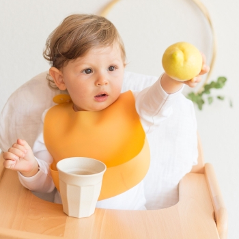 Baby am Tisch mit seinem Silikonlätzchen