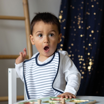 Baby mit seiner gestreiften Mutterschürze
