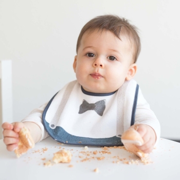 Baby beim Kuchenessen, geschützt durch sein Gentleman-Lätzchen