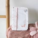 Capa de caderneta de saúde para menina pousada sobre uma pequena mesa