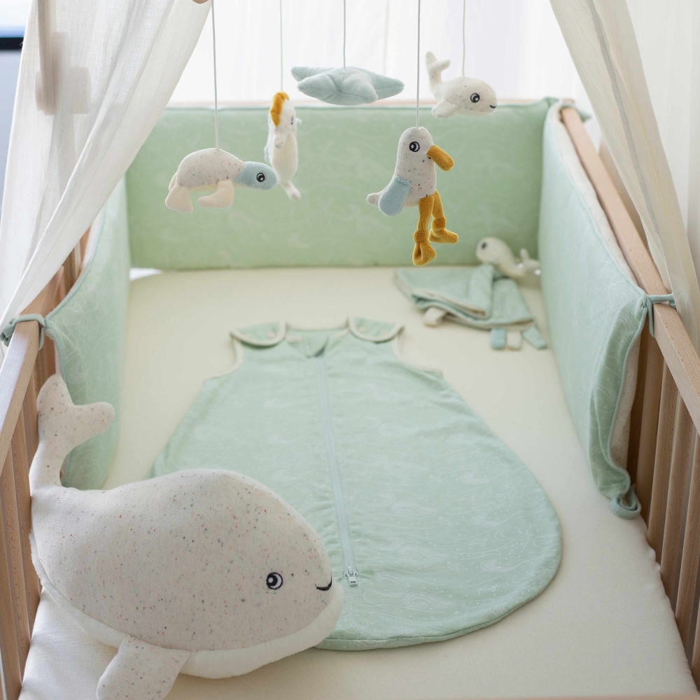 whale plush toy in a baby crib with bed linen whale plush toy in a baby crib with bed linen