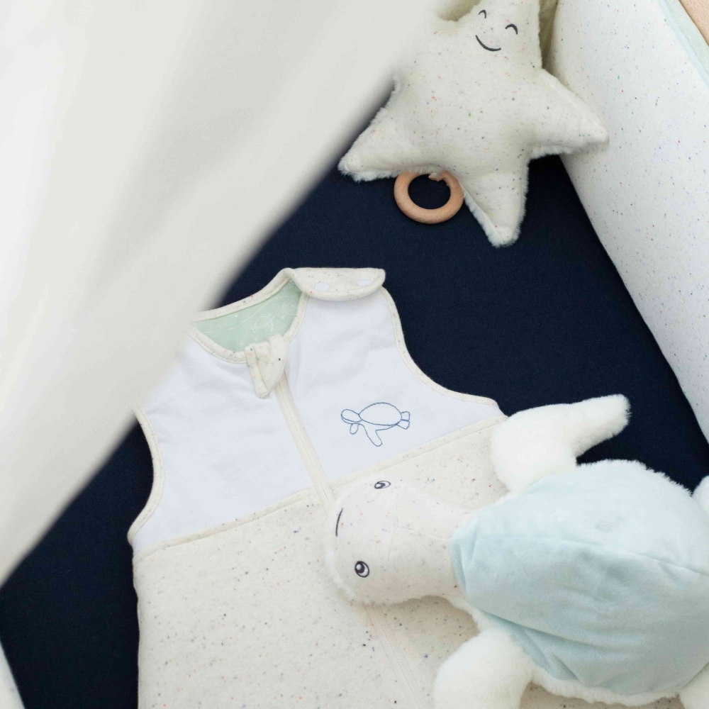 melierter bestickter Schlafsack im Babybett