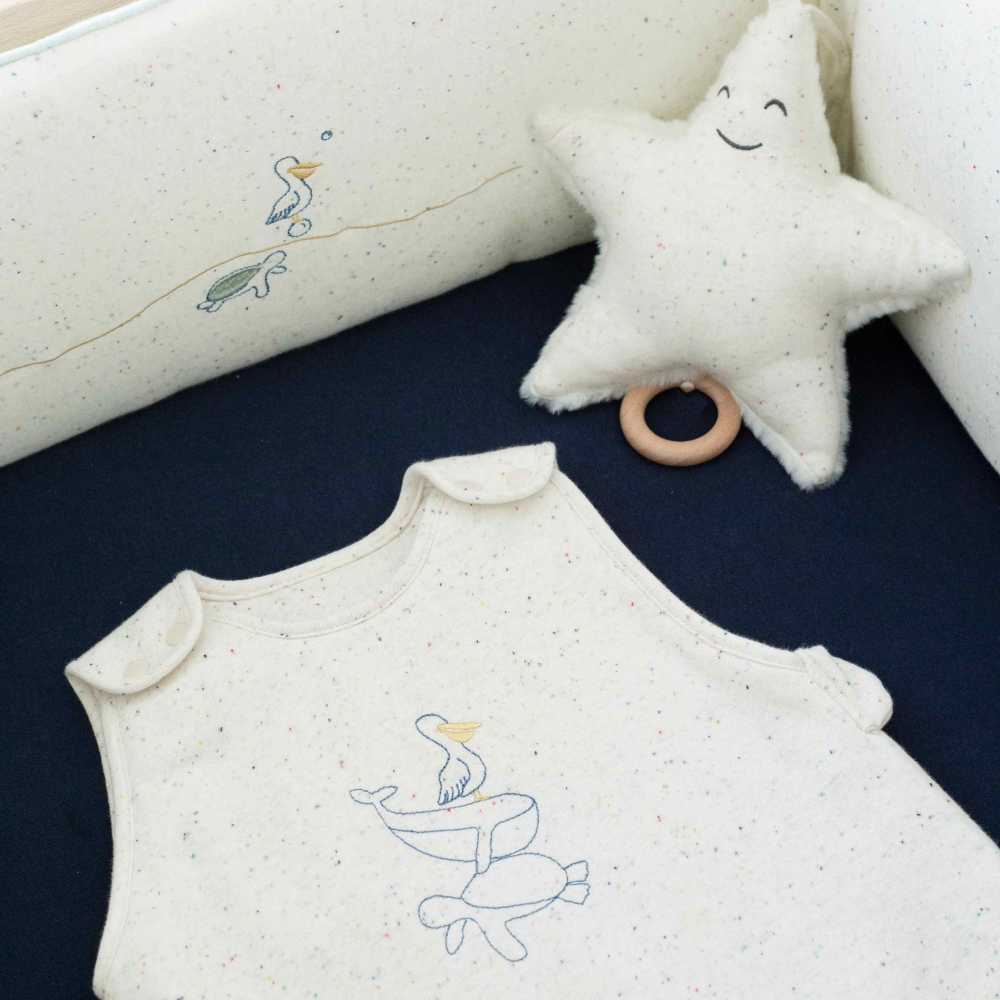 saco de dormir au large de nova 90cm, beige jaspeado en una cama.