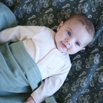 bébé avec ses langes à motifs feuilles tropicales bébé avec ses langes à motifs feuilles tropicales