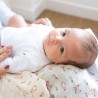 Baby lying on mother's lap with terracotta geese swaddle Baby lying on mother's lap with terracotta geese swaddle