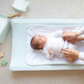foto di un bambino sul suo materassino per il cambio Nova verde acqua con motivi oceanici