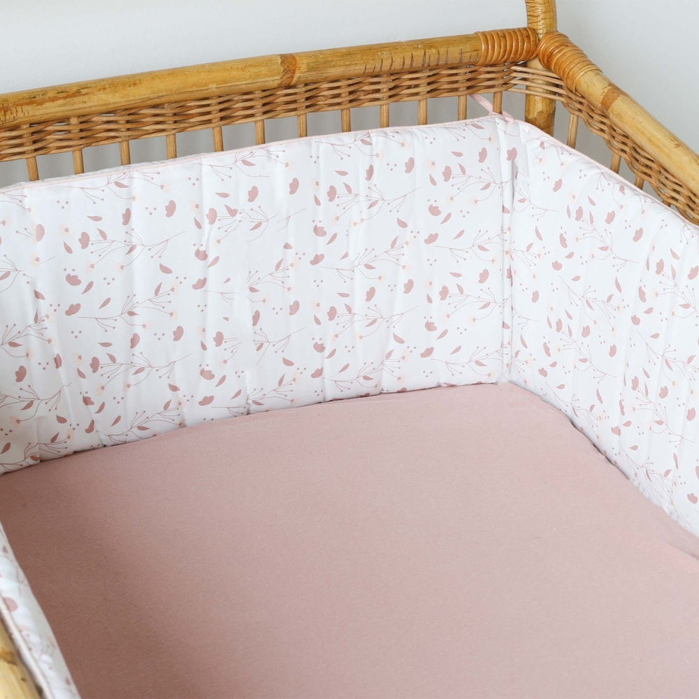 Staging of the floral bed bumper in a wicker bed with an old pink fitted sheet Staging of the floral bed bumper in a wicker bed with an old pink fitted sheet
