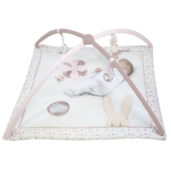 Pink and white play mat with a small baby lying on it