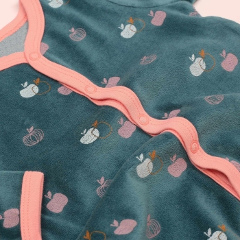Zoom nos motivos de maçãzinhas e o material veludo do pijama