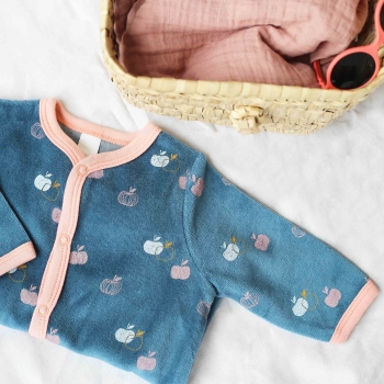 Photo mise en scène du pyjama bébé fille avec un petit panier en osier Photo mise en scène du pyjama bébé fille avec un petit panier en osier