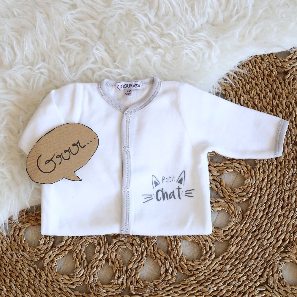 mise en scène du pyjama blanc et gris petit chat posé sur un tapis blanc mise en scène du pyjama blanc et gris petit chat posé sur un tapis blanc
