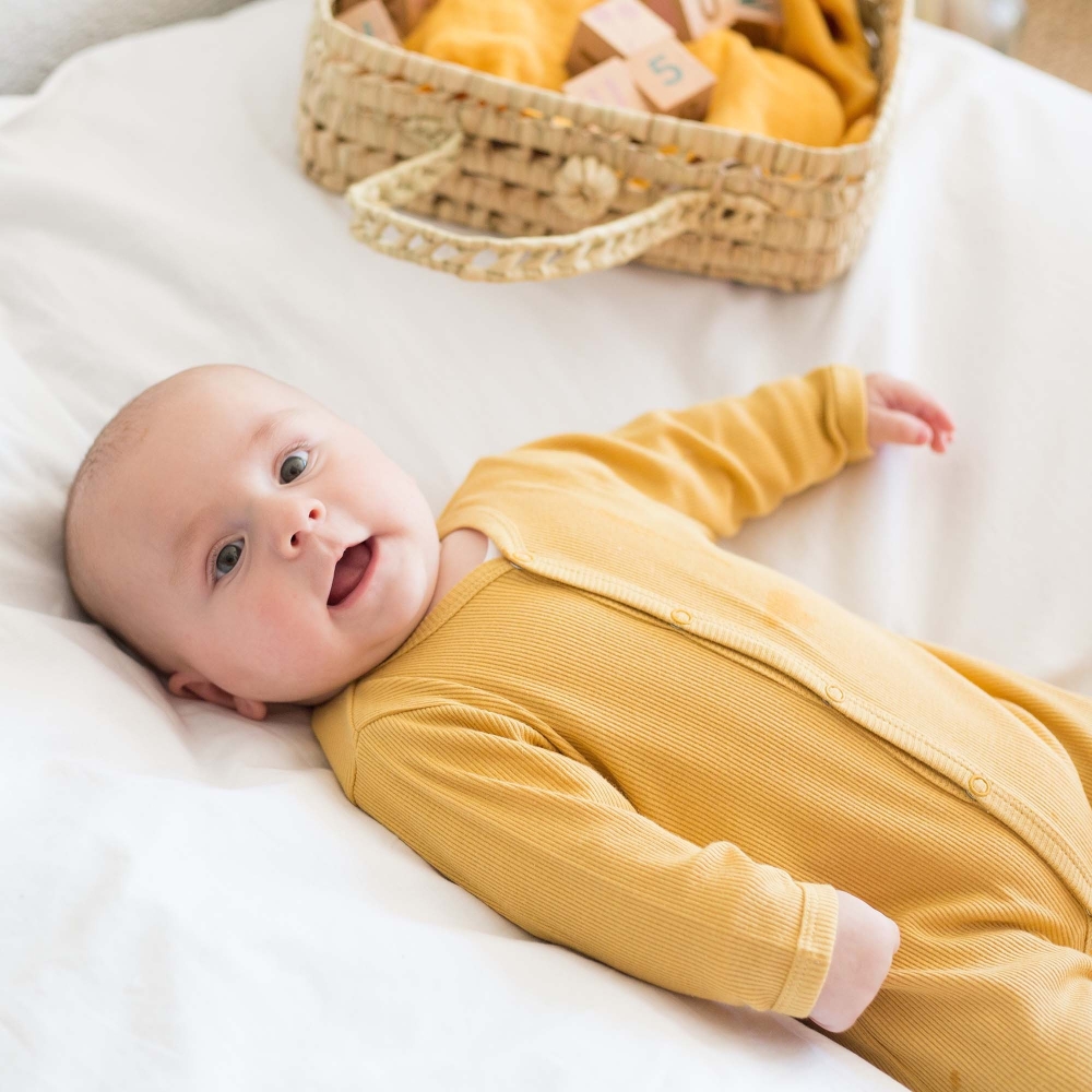 bebé en su pijama de canalé mostaza