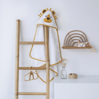 Serviette de bain avec capuche posé sur une échelle décorative de salle de bain Serviette de bain avec capuche posé sur une échelle décorative de salle de bain