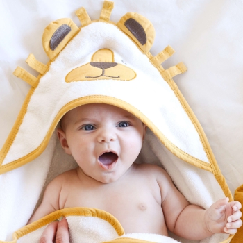 Baby, das das Brüllen des Löwen in seinem Neugeborenen-Bademantel nachahmt