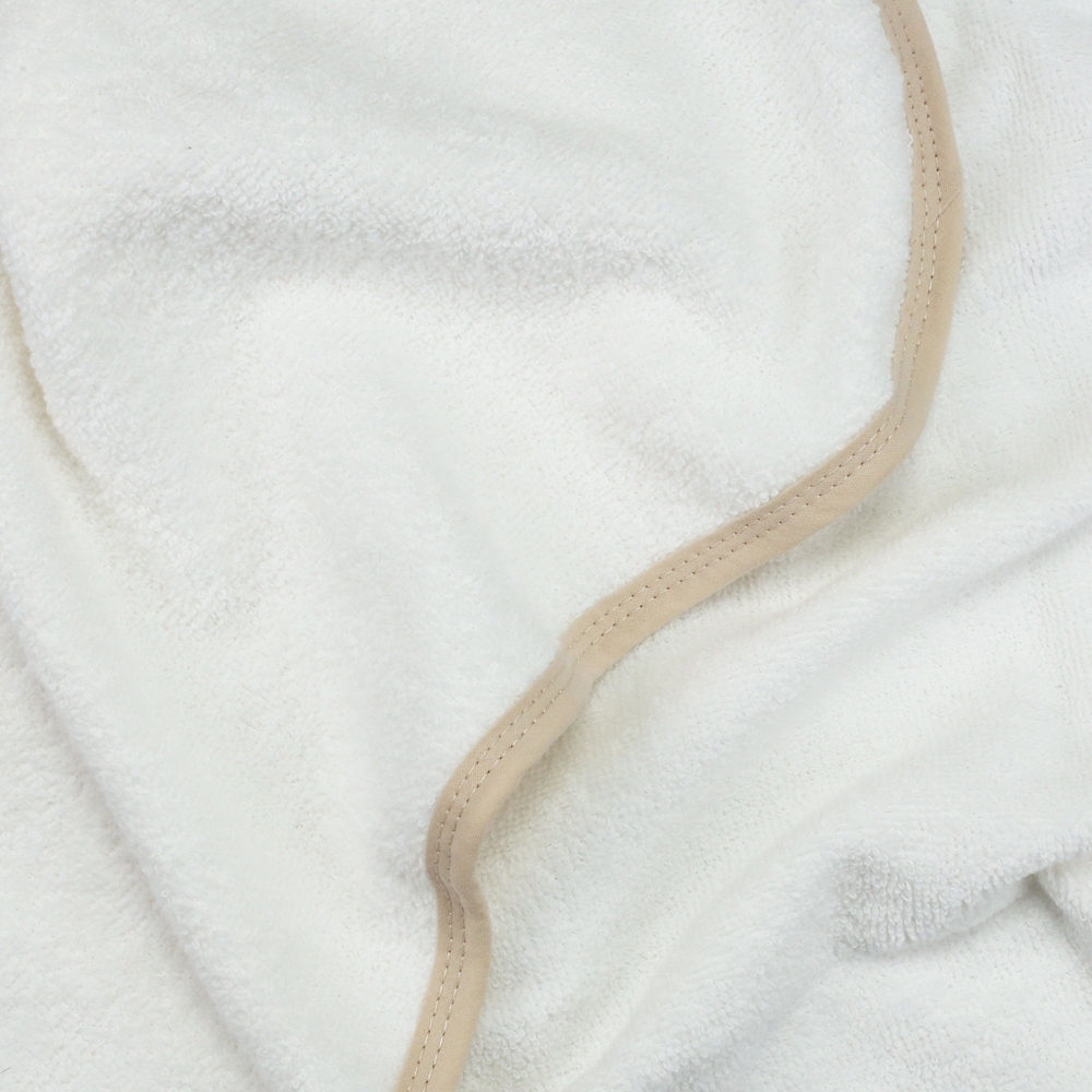 Zoom de materia sobre el rizo blanco y el ribete beige