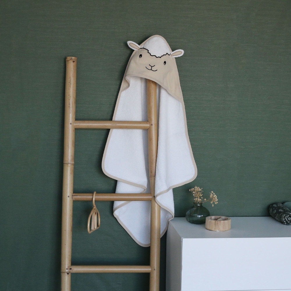 Saída de banho ovelha pousada numa escada decorativa na casa de banho Saída de banho ovelha pousada numa escada decorativa na casa de banho