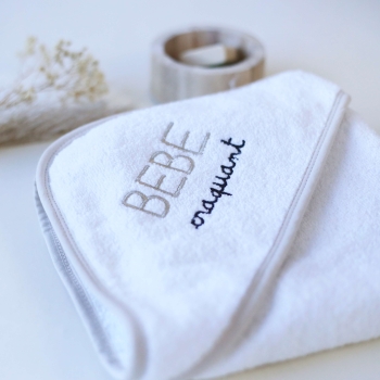 Staged photo of the folded baby bath towel with its embroidered inscription "irresistible baby"