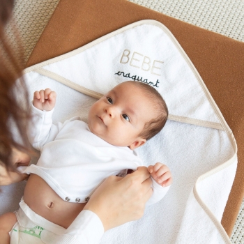 Baby, das von seiner Mama auf dem Baby-Bademantel "süßes Baby" gewickelt wird