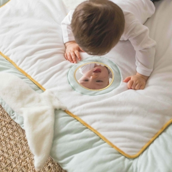 Baby die zichzelf bekijkt in de spiegel van de speelmat Baby die zichzelf bekijkt in de spiegel van de speelmat