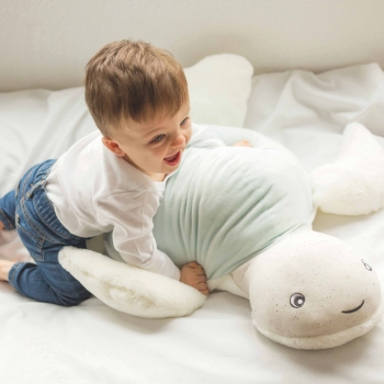 Baby playing with their big soft turtle stuffed animal