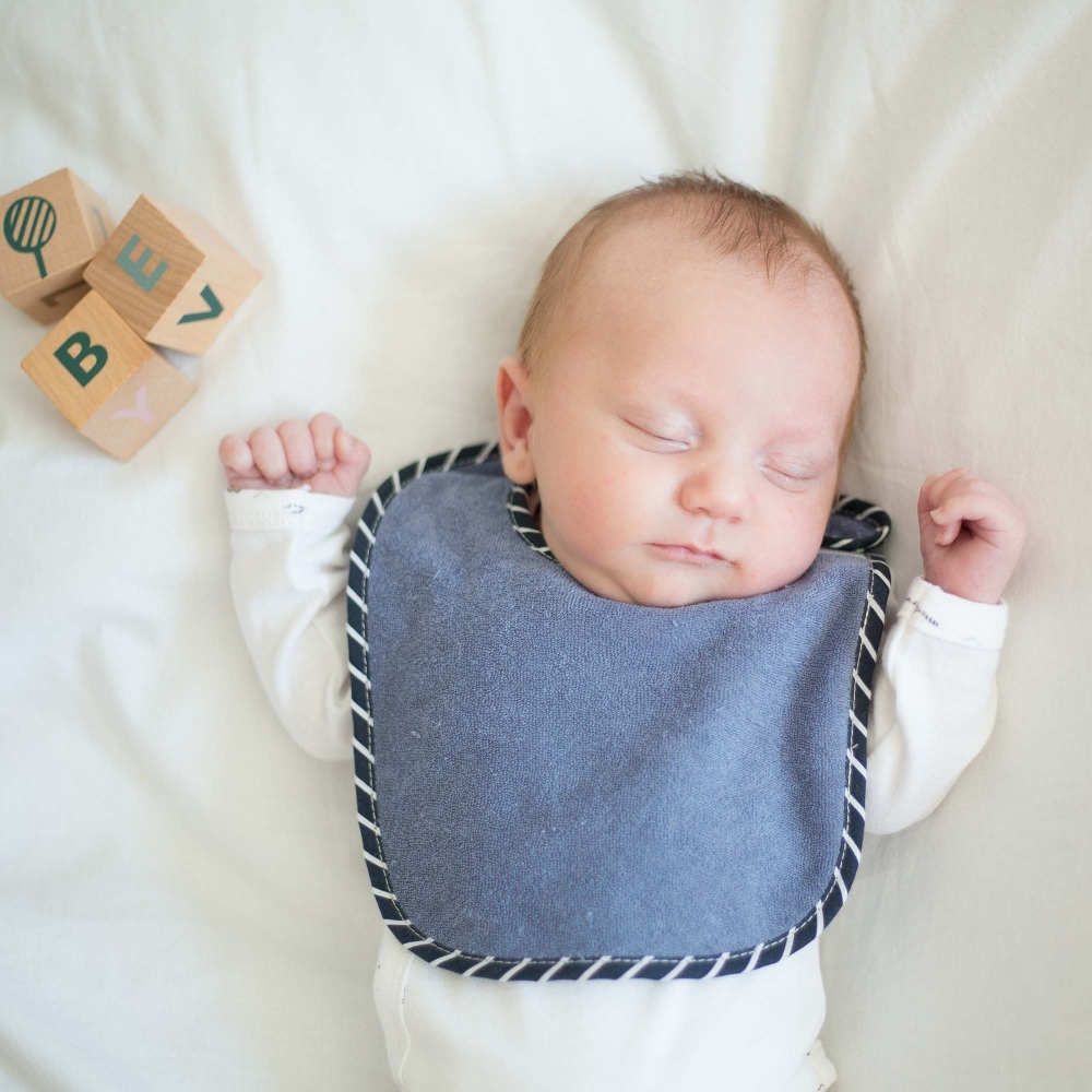 bébé garçon avec son beau bavoir bleu uni bébé garçon avec son beau bavoir bleu uni