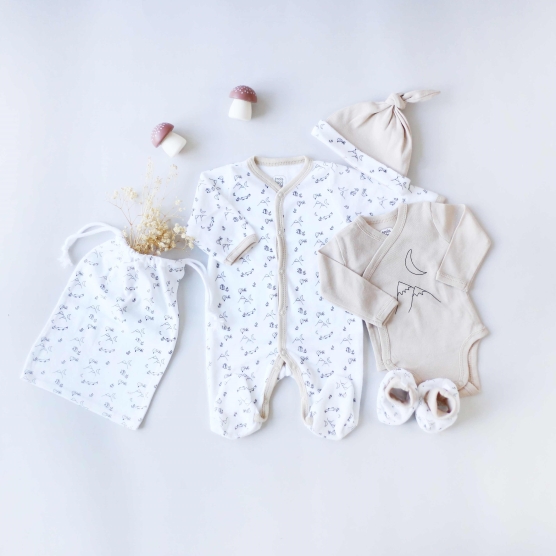 Ensemble naissance beige et blanc composé du pyjama, body, chaussons, bonnet et sac de rangement