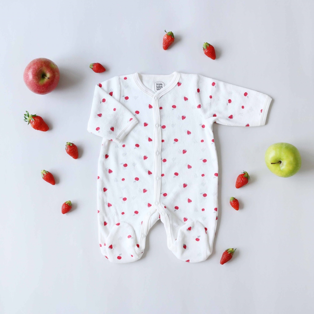 Mise en scène du pyjama fraises avec des vraies fraises et des pommes sur le côté Mise en scène du pyjama fraises avec des vraies fraises et des pommes sur le côté