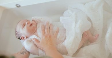 bebe dans son bain enveloppé dans un lange