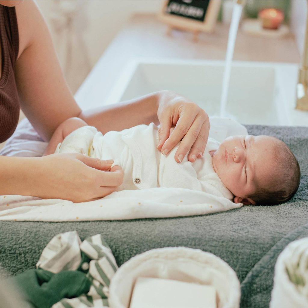 Bébé sur son matelas à langer à la sortie du bain