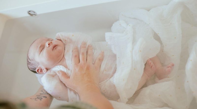 bebe dans son bain enveloppé dans un lange