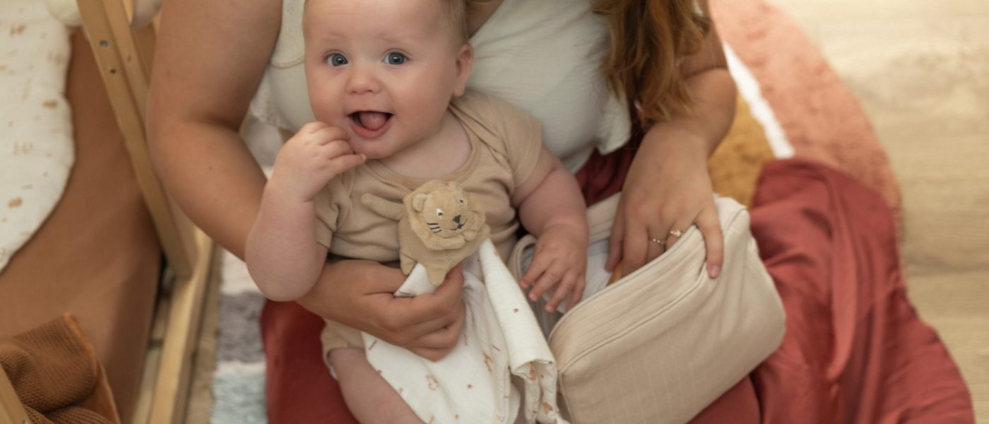 maman et son bébé qui jouent avec un doudou lion