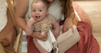 maman et son bébé qui jouent avec un doudou lion