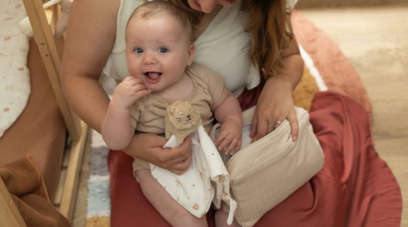 maman et son bébé qui jouent avec un doudou lion
