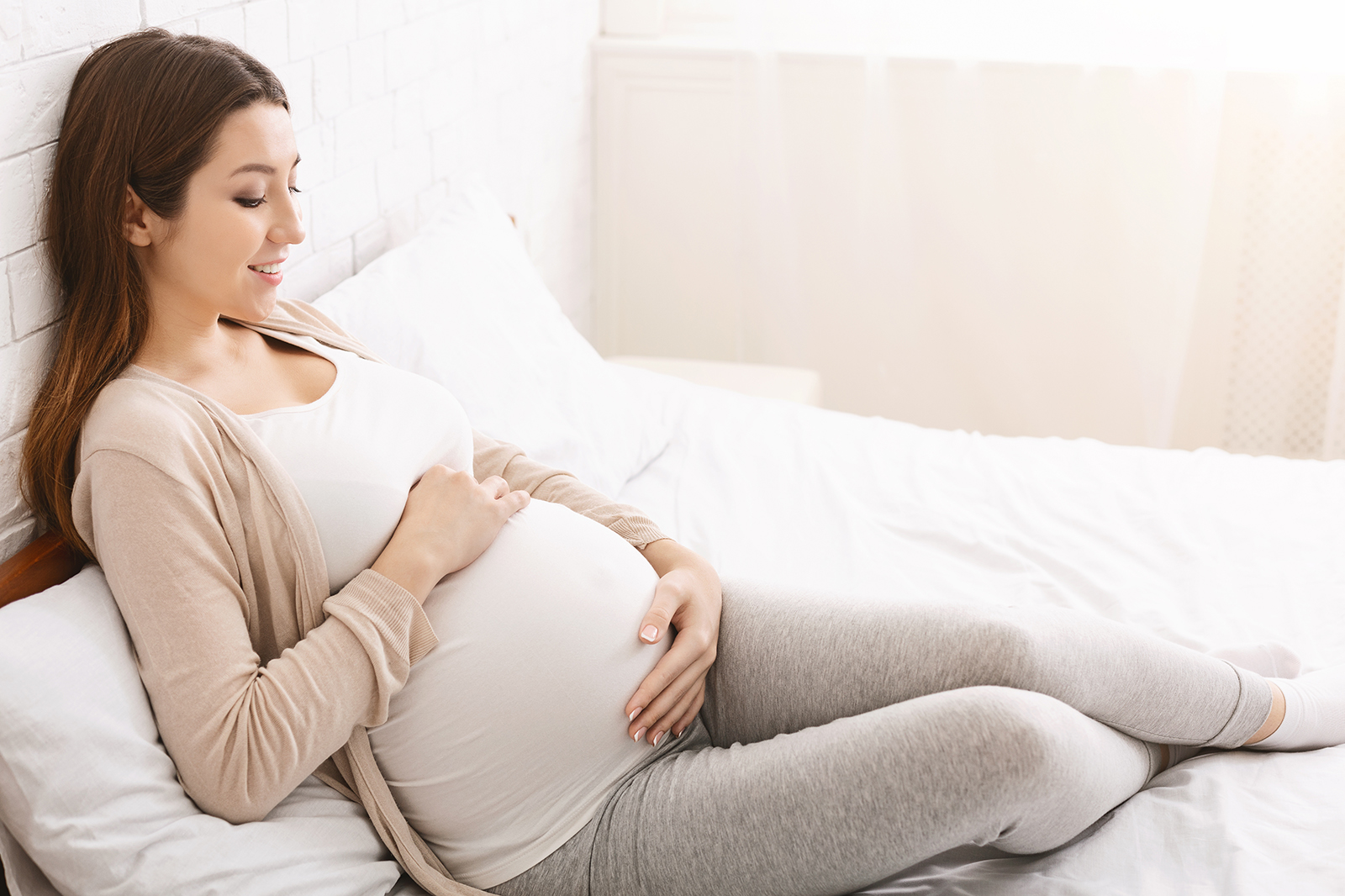 Femme enceinte avec tenue confortable beige et grise