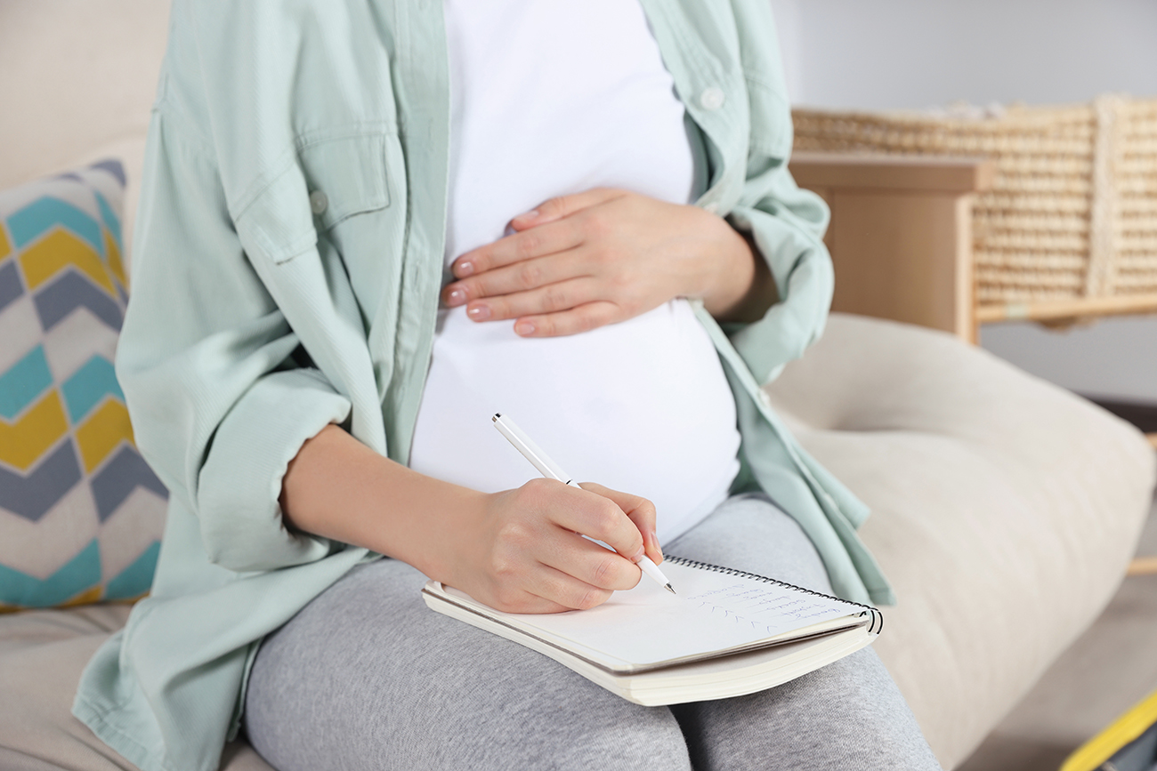 femme enceinte qui prépare sa valise de maternité